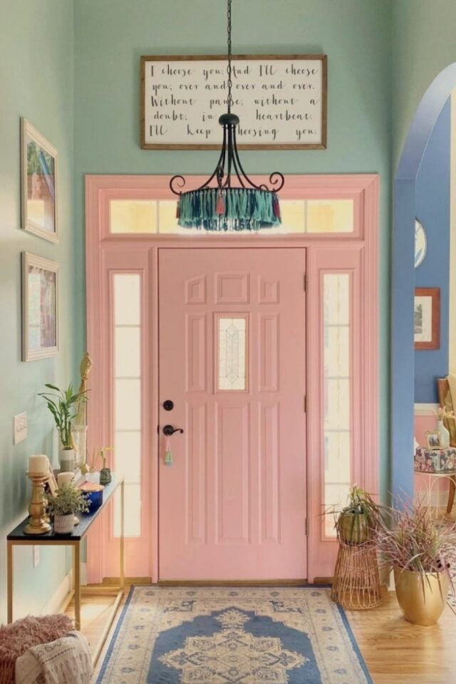 entrée de maison lumineuse avec mur vert clair porte rose pastel lustre vintage 