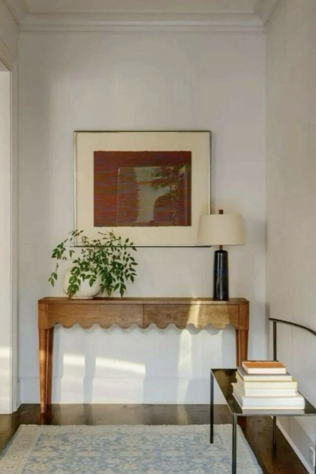 petite entrée avec peu de lumière naturelle mur blanc console en bois moderne tapis pour éclaircir le sol 