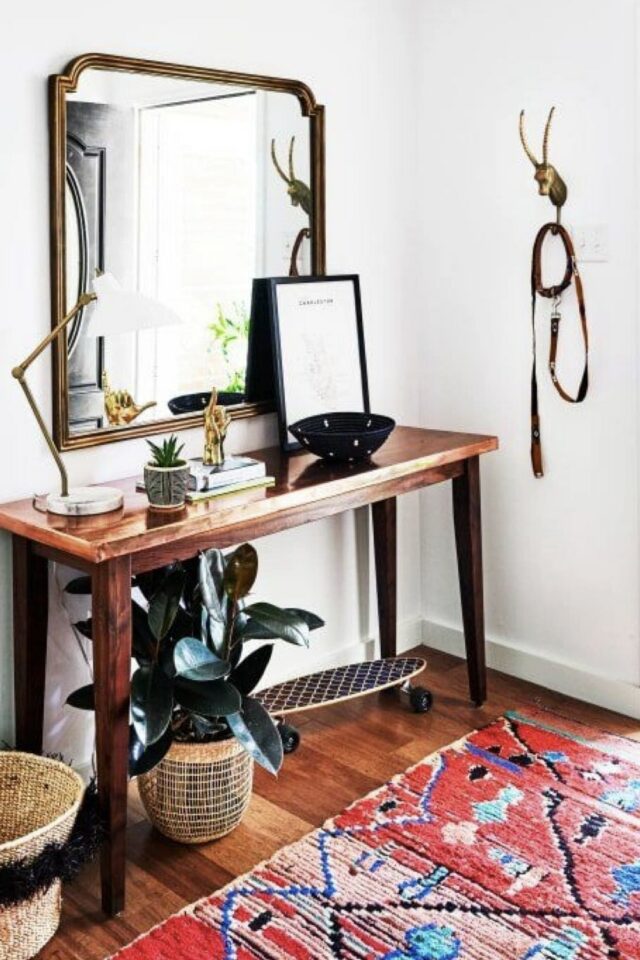 entrée blanche avec console en bois vintage miroir mural et tapis coloré rouge motif bleu 