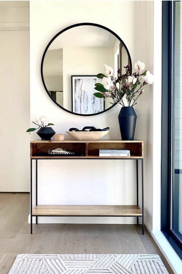 console en bois clair avec stucture métal noir petite entrée miroir rond tapis espace lumineux 