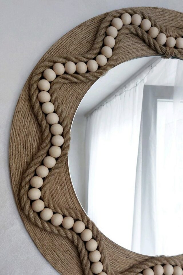 miroir rond relooké ambiance bord de mer ficelle naturelle et perles en bois qui forment un motif d'étoile 