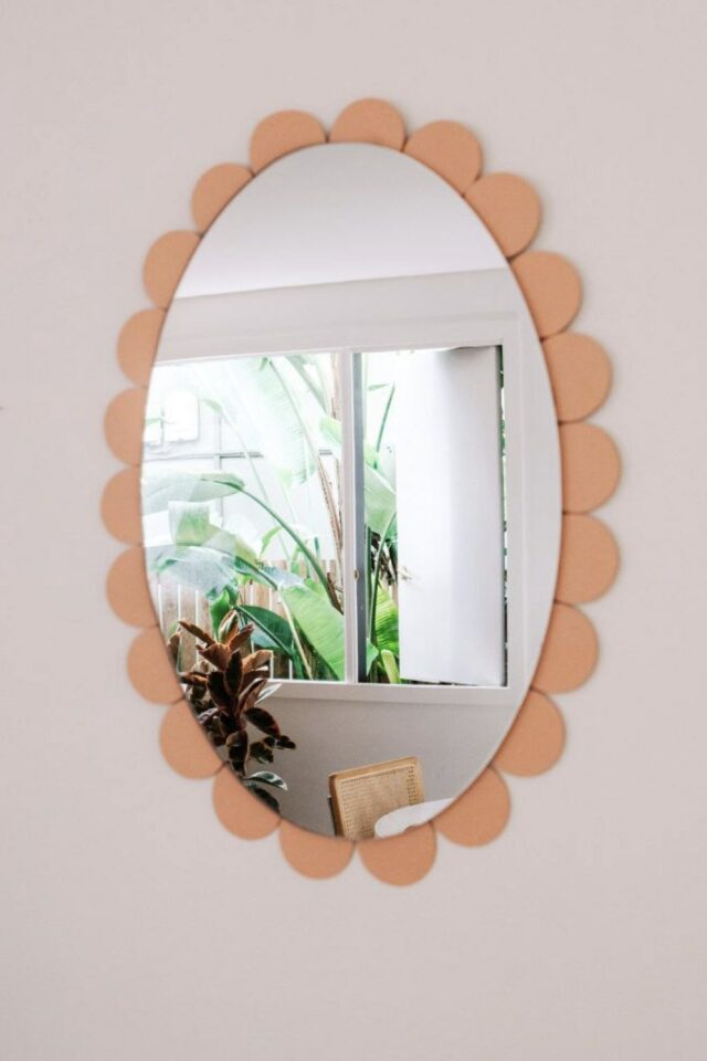 miroir oval relooké moderne collé sur une plaque de MDF découpée en feston et peinte en corail pêche 
