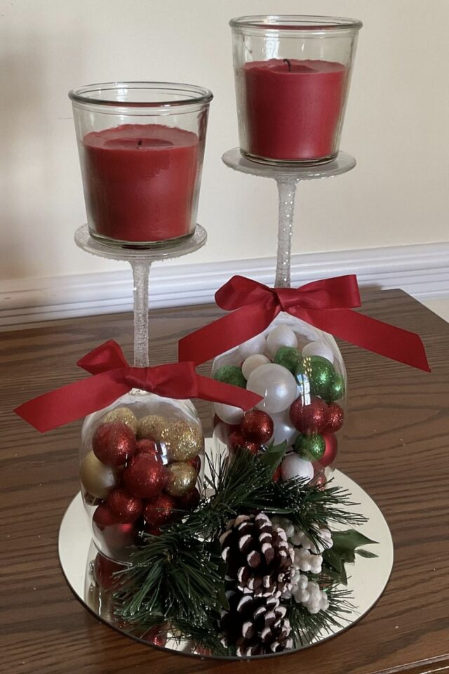 centre de table de Noël avec des verres à pieds retournée boule de sapin bougie et ruban 